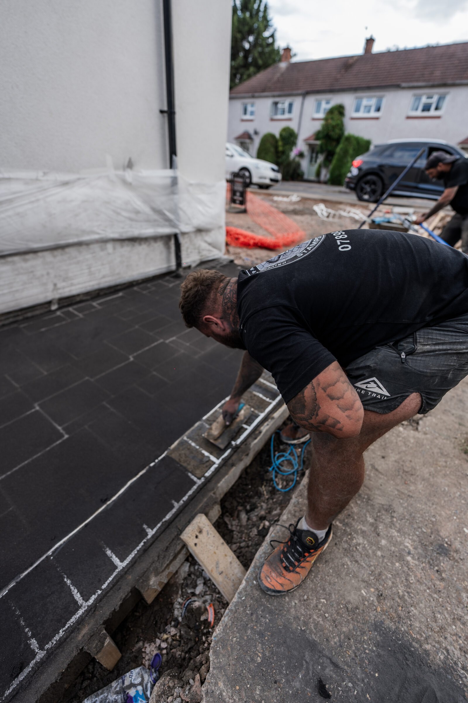 Pattern-imprinted concrete border being finished by hand