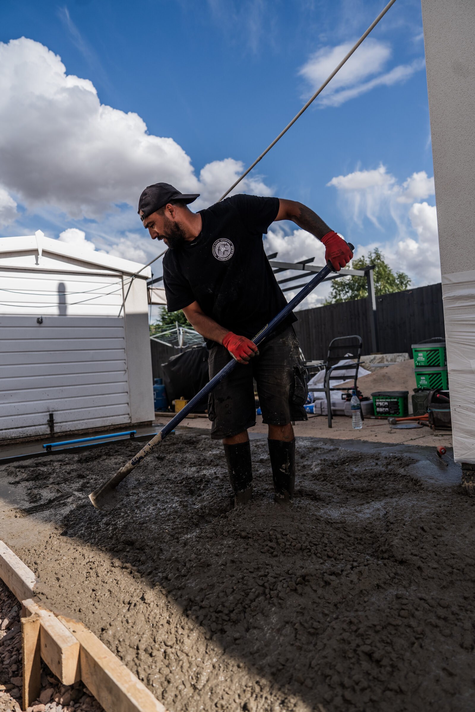 Fresh concrete being spread across the prepared driveway area